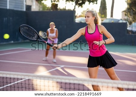 Active young tennis girl dressed in pink t-shirt and skirt on court ready for playing and training. Sport and healthylife concept