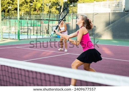 Active young tennis girl dressed in pink t-shirt and skirt on court ready for playing and training. Sport and healthylife concept