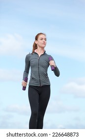 Active Young Woman Keeping Fit By Power Walking Outdoors