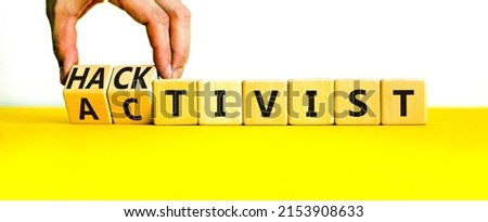 Activist or hacktivist symbol. Businessman turns wooden cubes and changes the word Activist to Hacktivist. Beautiful yellow table white background, copy space. Business activist or hacktivist concept.