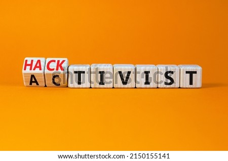 Activist or hacktivist symbol. Turned wooden cubes and changed the concept word Activist to Hacktivist. Beautiful orange table orange background, copy space. Business activist or hacktivist concept.