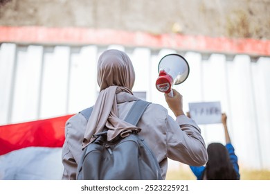 An activist passionately holding a megaphone, advocating for change during a peaceful rally event - Powered by Shutterstock