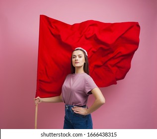 activist and revolutionary, young woman with a red flag on a pink background. Feminism and the struggle for rights, concept
