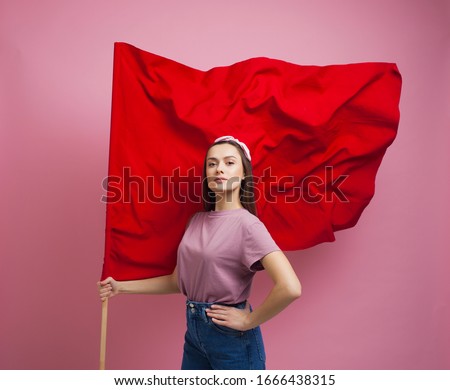 activist and revolutionary, young woman with a red flag on a pink background. Feminism and the struggle for rights, concept