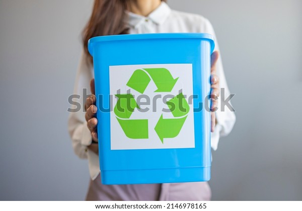 Activist taking care of\
environment during sorting waste to proper recycling bin at home.\
Separating waste to save resources. Close Up Of Woman Carrying\
Recycling Bin 