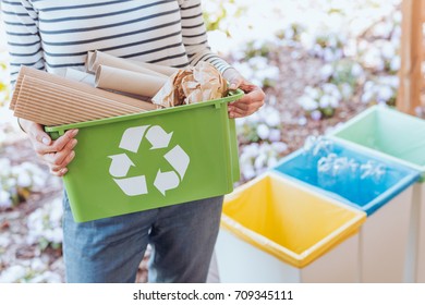 Activist taking care of environment, sorting paper waste to proper recycling bin on terrace - Shutterstock ID 709345111