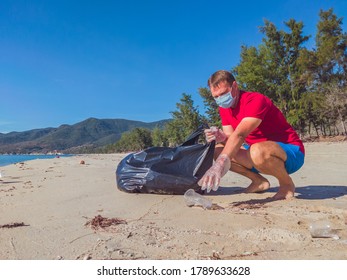 Activist volunteer Man in medical face mask pick up garbage that pollute beach sand near sea. Problem of spilled rubbish trash caused by man-made, planet pollution and environmental protection concept - Powered by Shutterstock