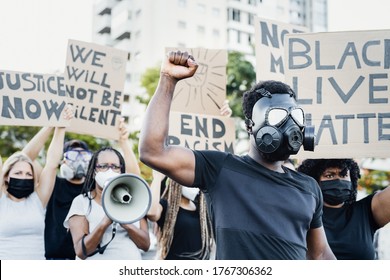 Activist wearing gas mask protesting against racism and fighting for equality - Black lives matter demonstration on street for justice and equal rights - Blm international movement concept