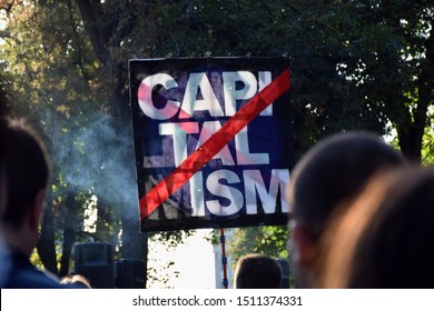 Activists holding capitalism sign on the poster at the protests. 