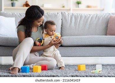 Activities With Babies. Loving Young Black Mom Playing Toys With Cute Infant Son At Home, Caring African American Mother Bonding With Her Toddler Kid, Relaxing In Living Room Together, Copy Space