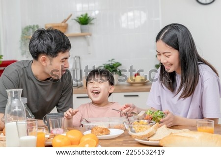 activities together during the holidays. Parents and children are having a meal together during the holidays. boy is teasing his father by giving him bread and vegetables.