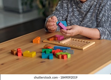 Activity Can Improve Brain Function. Elderly Woman Sitting At Table And Sorting Jigsaw Puzzle Pieces, Free Space Game