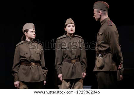 Actor and actress in military uniforms of the Soviet army of World War II play a performance on stage in the theater