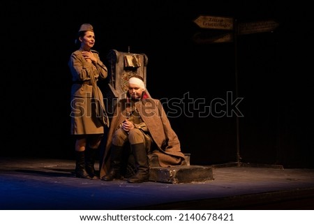 Actor and actress in military uniforms of the Soviet army of World War II play a performance on stage in the theater