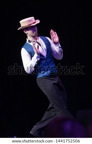 Actor dancer young man performs in a theater on stage in a dance musical show