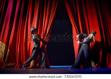 the actor opens a theater curtain