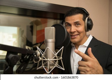 actor and radio announcer with headphones and microphone working film dubbing, performing radio spot and singing