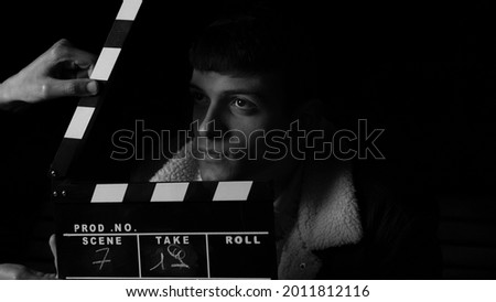 Actor ready for the ciak cinema scene during the production of short film in the night. Man inside a black and white movie set before the ciak. Background board black enternaiment scene hollywood 