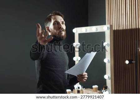 Actor with script rehearsing his lines in dressing room