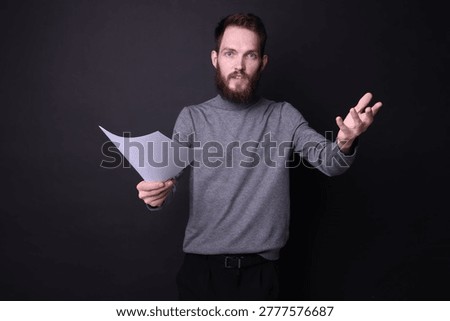 Actor with script rehearsing on black background