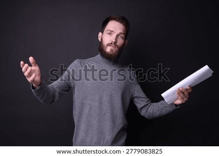 Actor with script rehearsing on black background