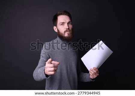 Actor with script rehearsing on black background