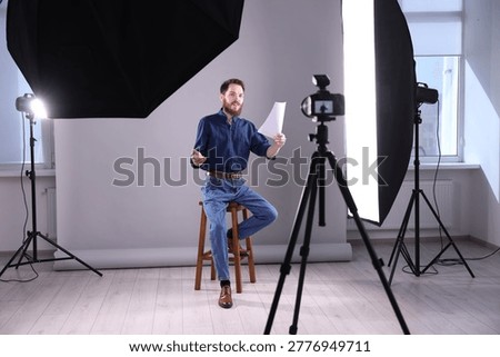 Actor with script rehearsing on light grey background