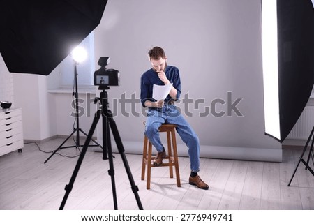 Actor with script rehearsing on light grey background
