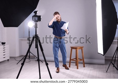 Actor with script rehearsing on light grey background