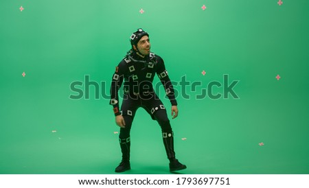 Actor Wearing Motion Caption Suit and Head Rig acts as an Animal or a Monster for CGI Green Screen Scene. Big Budget Filmmaking On Film Studio Set Shooting Blockbuster Movie with Chroma Key