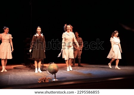 Actors men in the military uniform of the army of the Second World War and girls in retro dresses play a performance on the stage of the theater