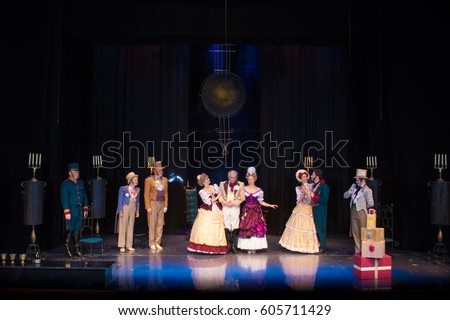 Actors, men in old clothes frock coats and uniforms and women in medieval dresses with lush skirts posing on stage in the background of scenery