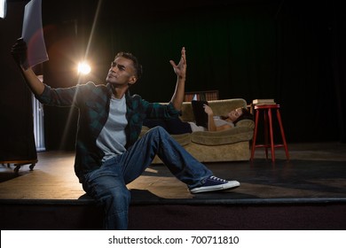 Actors Reading Their Scripts On Stage In Theatre