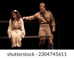 Actors in retro military uniforms of the army of World War II play a performance on stage in the theater