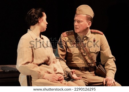 Actors in retro military uniforms of the army of World War II play a performance on stage in the theater