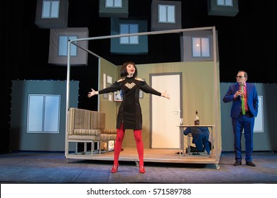 Actress Brunette Woman In A Sexual Manner And Actor Man In A Blue Suit On A Background Of A Theater Stage With Scenery For The Play.