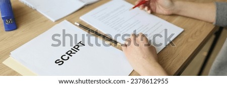 Actress checks script papers for filming movie making notes with pencil. Woman edits text at wooden table in office and prepares for playing role
