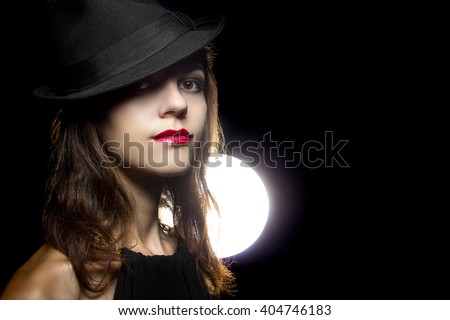 Actress with classic smoky dark make up in Hollywood film noir style.  Her cosmetic make up style is dark and a retro look.