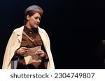 Actress in retro military uniforms of the army of World War II play a performance on stage in the theater