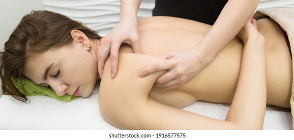 Acupressure Medical Massage On Back Of A Young Woman.