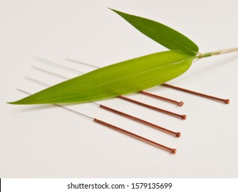 Acupuncture needles with bamboo leaf  background