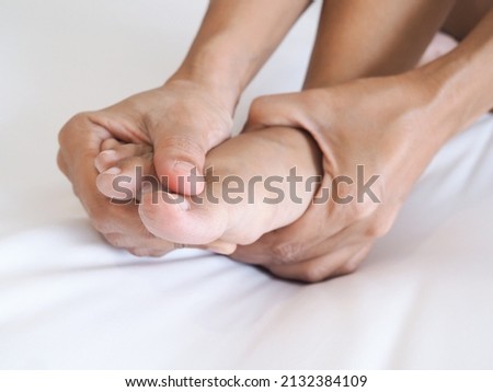 Acute foot pain of thai Asian women and massage on feet to relieve severe sore feet. Medical health care concept.