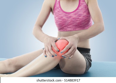 Acute Pain In A Knee. Woman Holding Hand To Spot Of Knee-aches.