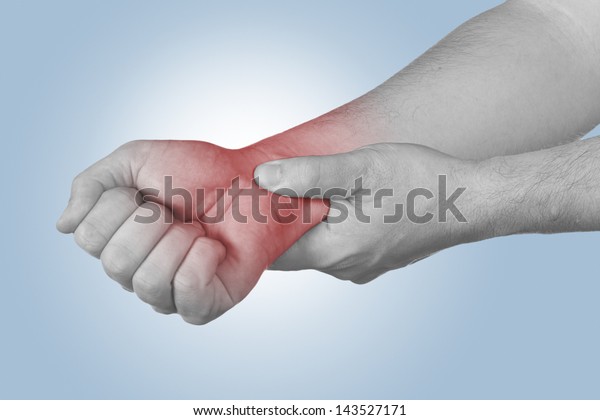 Acute pain in a man wrist. Male holding hand to\
spot of wrist pain.