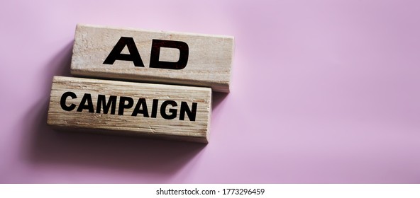 Ad Campaign On Wooden Blocks On Pink Background. Marketing Advertising Business Concept