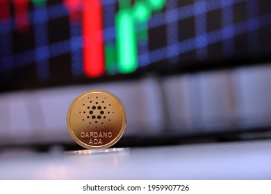 Ada Cardano Coin Sitting On A Desk With A Red And Green Background Chart Computer Pc Screen