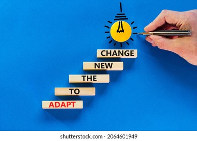 Adapt to the new change symbol. Wooden blocks with words Adapt to the new change on blue background, copy space. Light bulb icon. Businessman hand with pen. Business, adapt to change concept.