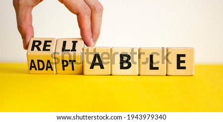 Adaptable or reliable symbol. Businessman turns wooden cubes and changes the word adaptable to reliable. Beautiful white background, copy space. Business and adaptable or reliable concept.