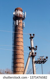 Adaptive Reuse Of An Old Industrial Building. Abandoned Factory Brick Tower With New, Modern Telecommunication Antennas. 