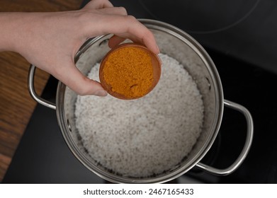 Add curry spice to rice in the pot close up - Powered by Shutterstock